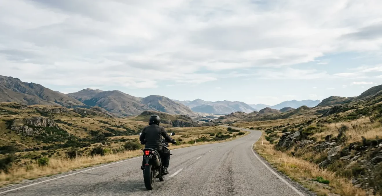 Motard sur route ouverte incarnant la liberté nécessitant protection