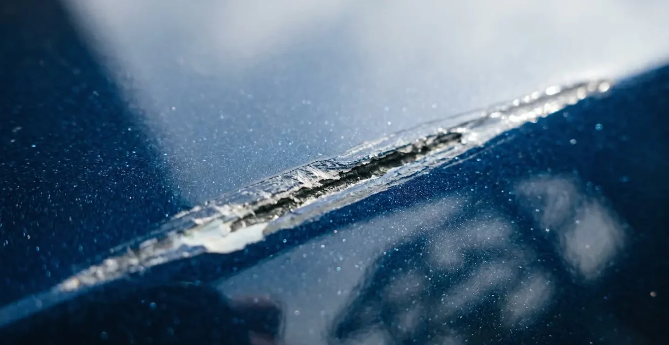 Détail d'une rayure sur carrosserie avec reflet naturel montrant l'étendue des dégâts
